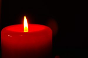 Idea in the Dark - Lit Red Candle, Black Background